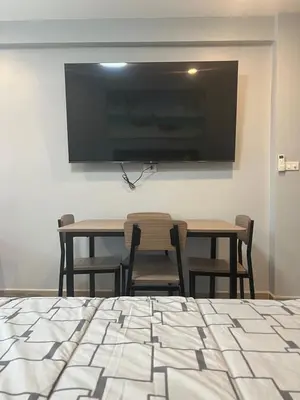 a dining room with two tables and a flat screen tv at Patong Vacation Condos by Pam - 28 SQM modern condos with private bathroom, kitchen, King Bed, free WiFi and 65 inch smart TC in Patong Beach