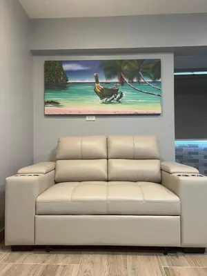 a living room with a couch and a painting on the wall at Patong Vacation Condos by Pam - 28 SQM modern condos with private bathroom, kitchen, King Bed, free WiFi and 65 inch smart TC in Patong Beach