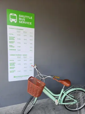 a bike with a basket parked next to a bus service sign at WEG NaiThon Beach in Nai Thon Beach