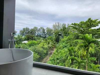 a bathroom with a tub and a view of a forest at WEG NaiThon Beach in Nai Thon Beach