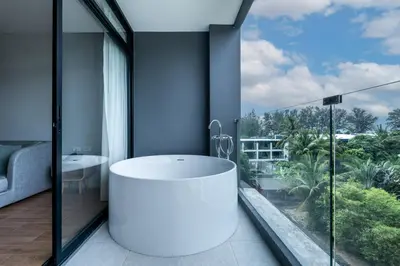 a bathroom with a white tub and a large window at WEG NaiThon Beach in Nai Thon Beach