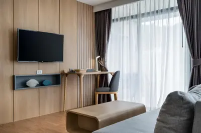 a hotel room with a bed and a tv and a chair at WEG NaiThon Beach in Nai Thon Beach