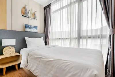 a bedroom with a white bed and a large window at WEG NaiThon Beach in Nai Thon Beach
