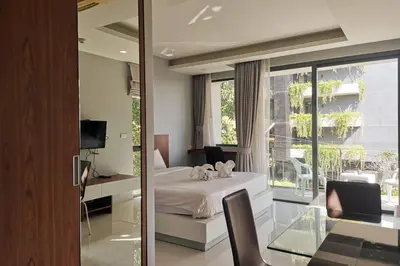 a bedroom with a bed and a desk and a window at At the Tree bright studio by Lofty in Rawai Beach