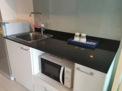 a kitchen with a sink and a microwave at The Pixel Cape Panwa Beach Condo in Panwa Beach