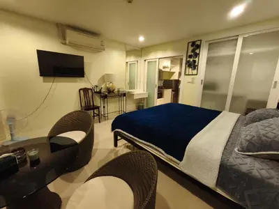 a bedroom with a bed and a table with chairs at The Pixel Cape Panwa Beach Condo in Panwa Beach
