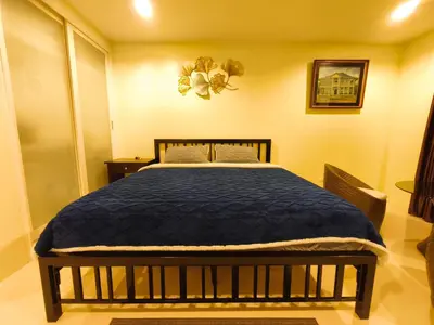 a bedroom with a bed with a blue comforter at The Pixel Cape Panwa Beach Condo in Panwa Beach
