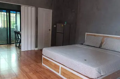 a bedroom with a bed in a room with a table at Studio Apartment 12 in Thalang in Ban Phak Chit