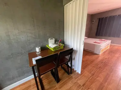 a room with a desk with a bed and a bedroom at Studio Apartment 12 in Thalang in Ban Phak Chit