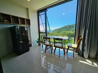 a dining room with a table and chairs and a large window at The viva patong condo C602 in Patong Beach