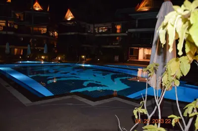 a swimming pool in the middle of a building at night at Kalim Residence in Patong Beach