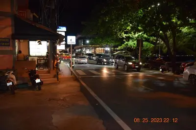 a city street at night with cars driving down the street at Kalim Residence in Patong Beach
