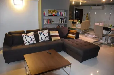 a living room with a brown couch and a table at Kalim Residence in Patong Beach