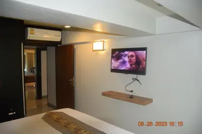 a bedroom with a tv on the wall at Kalim Residence in Patong Beach