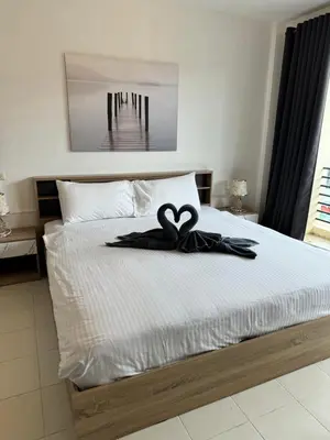 a bed with a black ribbon on top of it at Apartments Kata Beach in Kata Beach