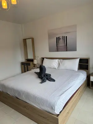 a large bed with a stuffed animal sitting on it at Apartments Kata Beach in Kata Beach