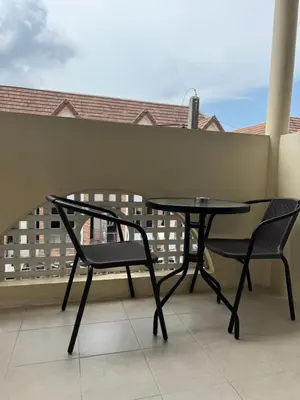 a table and two chairs on a balcony at Apartments Kata Beach in Kata Beach