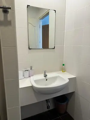 a white bathroom with a sink and a mirror at Apartments Kata Beach in Kata Beach