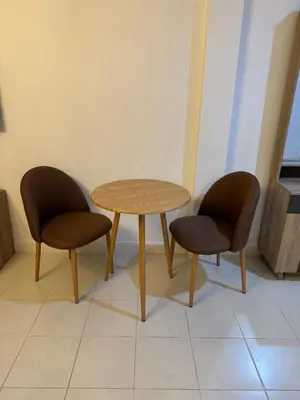 two chairs and a wooden table in a room at Apartments Kata Beach in Kata Beach