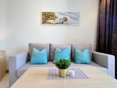 a living room with a couch and a table at Cozy Studio Rawai Beach Phuket in Ban Saiyuan (1)