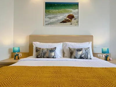 a bedroom with a large bed with two lamps at Cozy Studio Rawai Beach Phuket in Ban Saiyuan (1)