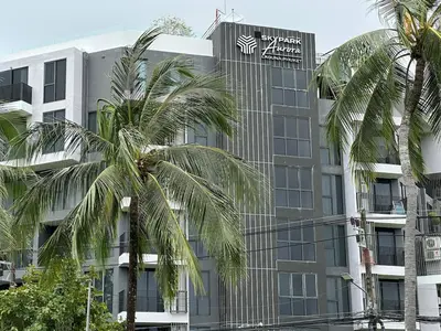 a building with palm trees in front of it at Laguna Skypark, 2 bedrooms & large terrace with golf view in Phuket Town