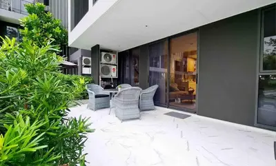 a patio with chairs and a table on a building at Laguna Skypark, 2 bedrooms & large terrace with golf view in Phuket Town