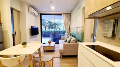 a kitchen and living room with a couch and a table at Laguna Skypark, 2 bedrooms & large terrace with golf view in Phuket Town