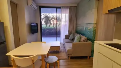 a living room with a couch and a table at Laguna Skypark, 2 bedrooms & large terrace with golf view in Phuket Town