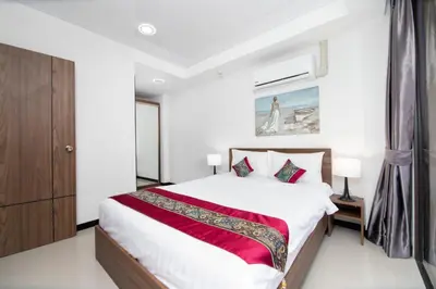 a bedroom with a large bed with a red blanket at Nai Harn Beach Condominimum in Phuket Town