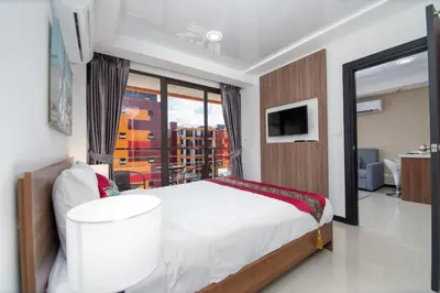 a bedroom with a bed and a large window at Nai Harn Beach Condominimum in Phuket Town