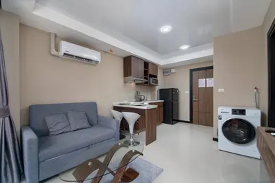 a living room with a couch and a kitchen at Nai Harn Beach Condominimum in Phuket Town