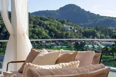 a couch on a balcony with a view of a mountain at Luxurious 5 bedroom 5 bathroom Gym Views v138 in Kamala Beach