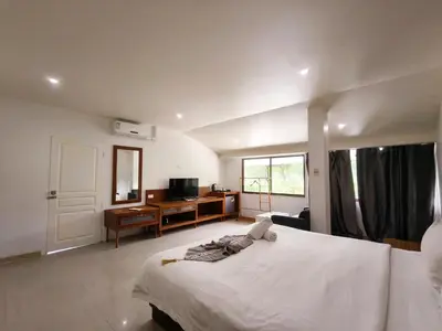 a bedroom with a bed and a desk and a television at V Beach Resort in Patong Beach