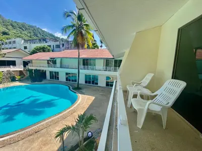 a balcony with two chairs and a swimming pool at V Beach Resort in Patong Beach