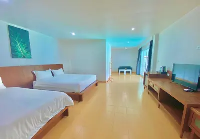 a bedroom with two beds and a flat screen tv at V Beach Resort in Patong Beach