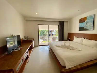 a bedroom with a large bed and a television at V Beach Resort in Patong Beach