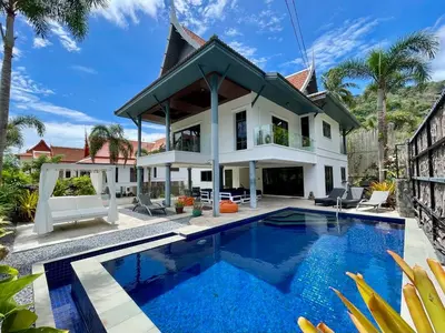 a villa with a swimming pool in front of a house at Kata Vista Luxury Modern 4BR Private Pool Villa in Kata Beach