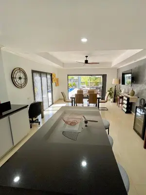 a living room with a large table and a dining room at Kata Vista Luxury Modern 4BR Private Pool Villa in Kata Beach