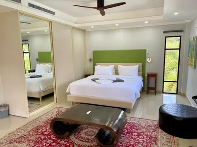 a bedroom with a large bed and a mirror at Kata Vista Luxury Modern 4BR Private Pool Villa in Kata Beach