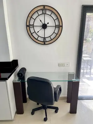 a desk with a chair and a clock on the wall at Kata Vista Luxury Modern 4BR Private Pool Villa in Kata Beach