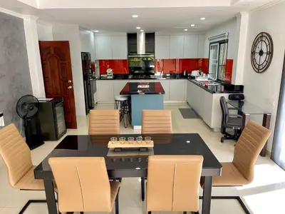 a kitchen and dining room with a table and chairs at Kata Vista Luxury Modern 4BR Private Pool Villa in Kata Beach