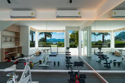 a gym with exercise equipment and large windows at Phuket 4-6 Bedroom Seaview Villa Infinity 25mPool In-Villa Dining & Butler Gym in Thalang
