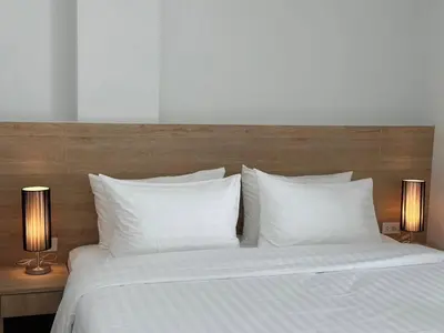 a large bed with white pillows and two lamps at BS KRABI HOTEL in Ban Khlong Haeng