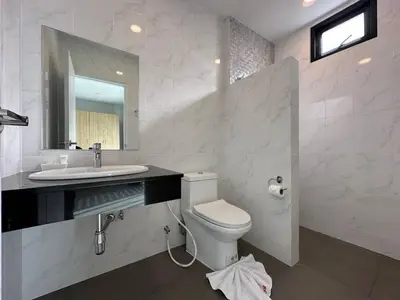 a bathroom with a toilet and a sink and a mirror at BS KRABI HOTEL in Ban Khlong Haeng