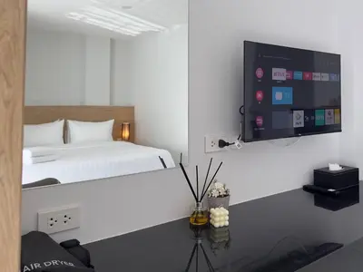 a bedroom with a bed and a flat screen tv at BS KRABI HOTEL in Ban Khlong Haeng