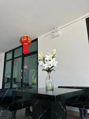 a vase with white flowers on a black table at BS KRABI HOTEL in Ban Khlong Haeng
