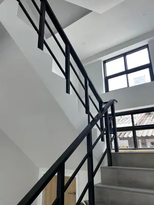 a staircase in a house with black railings at BS KRABI HOTEL in Ban Khlong Haeng