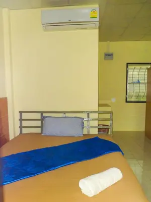 a bedroom with a bed with two towels on it at Bonus Bungalow in Chalong