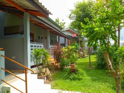 a house with a yard with trees and plants at Bonus Bungalow in Chalong